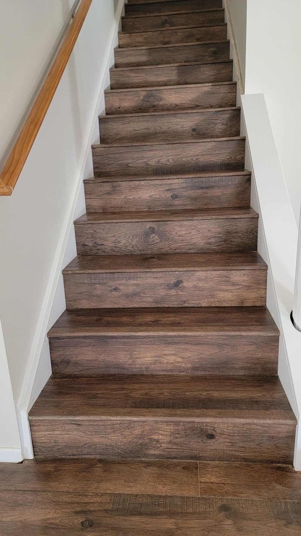 Wooden staircase with a sleek design, featuring dark brown steps and white railings.
